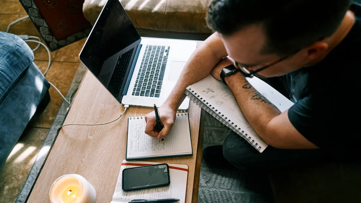 man in black t-shirt writing on white paper
